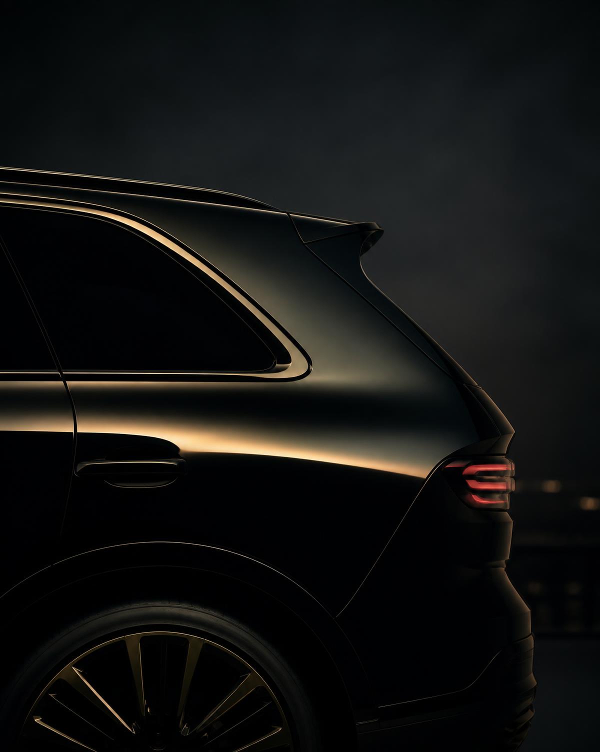 Detail of a black luxury SUV lit by warm golden light at night