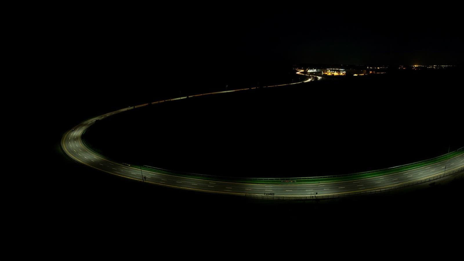 Aerial night view of a highway curving through open countryside